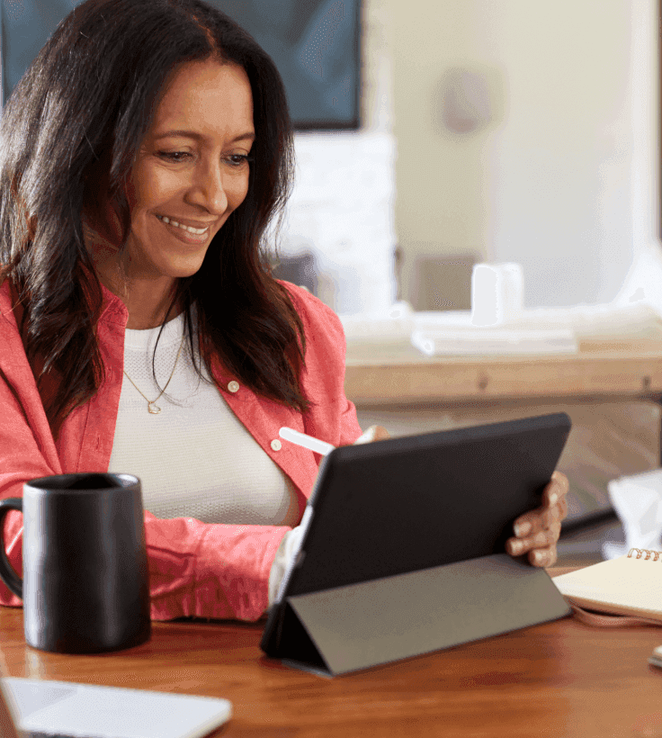 Um homem sorridente falando ao celular e usando o computador