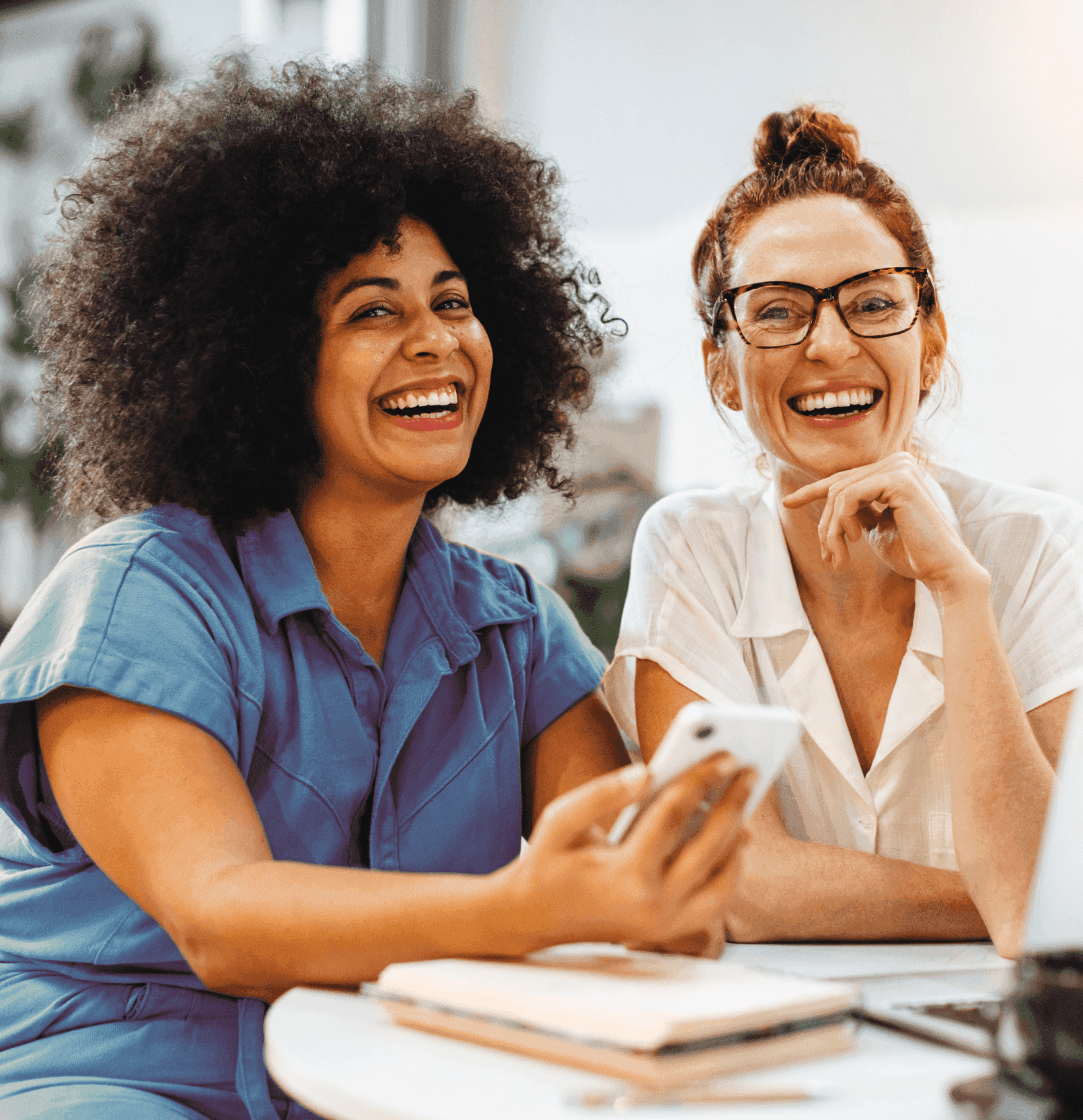 Duas pessoas olhando para o computador e sorrindo