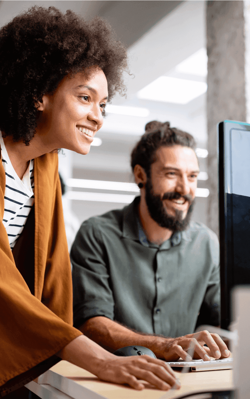 Um homem e uma mulher sorridente olhando para o computador