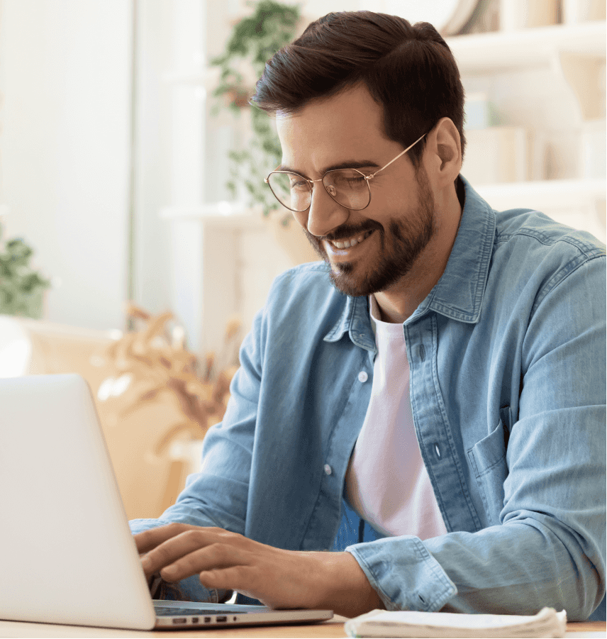 Homem sorridente olhando para o computador